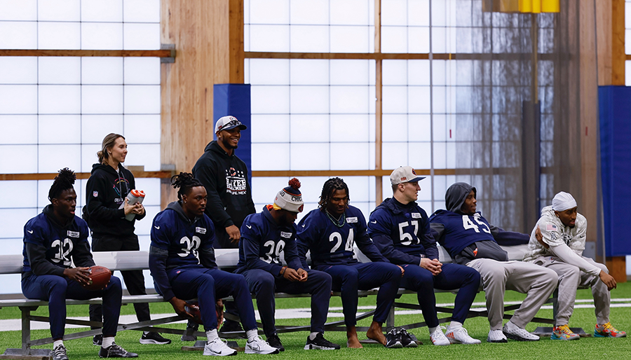 Carly Collins behind a bench of football players