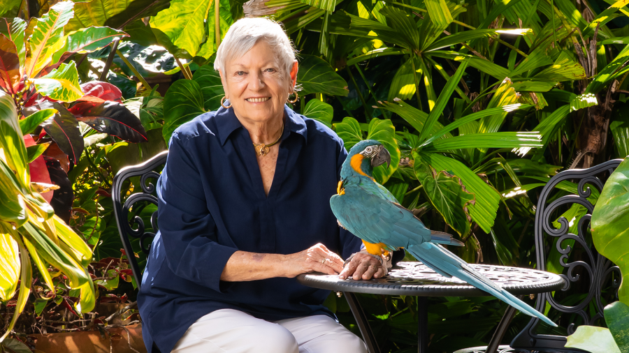 Sandy Shultz poses with a parrot