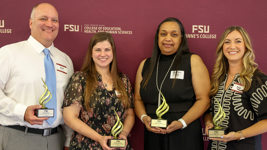 Four recipients of the 2026 Torch Awards pose with their awards