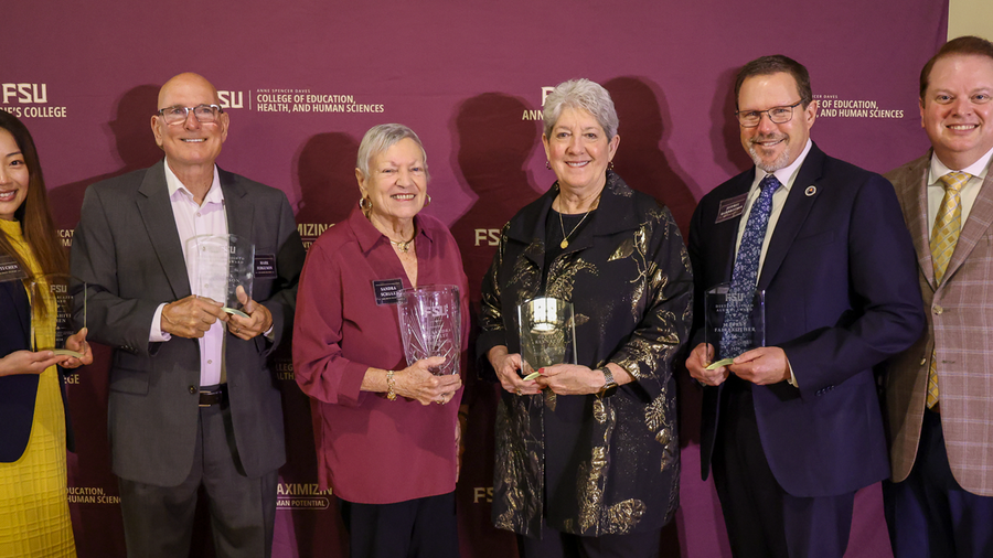 Five award recipients pose in a line with Dean Damon Andrew