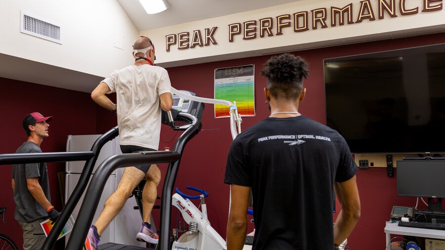 person running on treadmill wearing a vo2 max mask