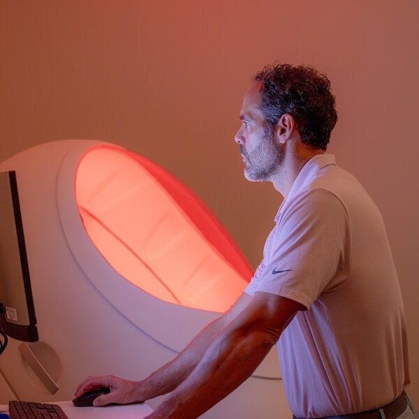 male looking at computer next to BODPOD machine