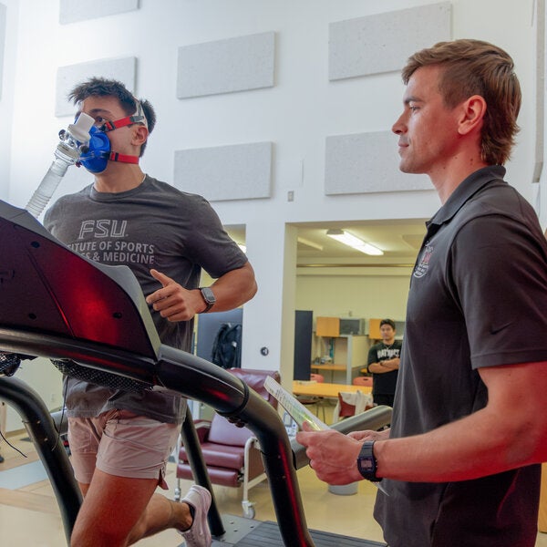 person running on treadmill wearing a vo2 max mask