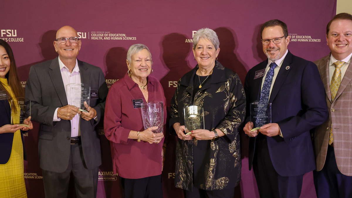 Five award recipients pose in a line with Dean Damon Andrew