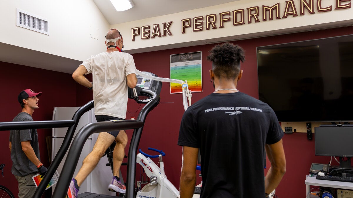 person running on treadmill wearing a vo2 max mask