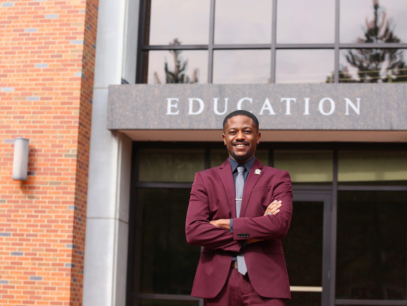 student in front of college of education