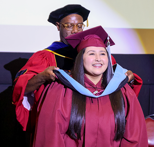 Doctoral student is hooded at the ceremony