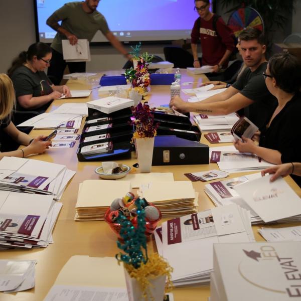 People sitting at a table assembling care packages