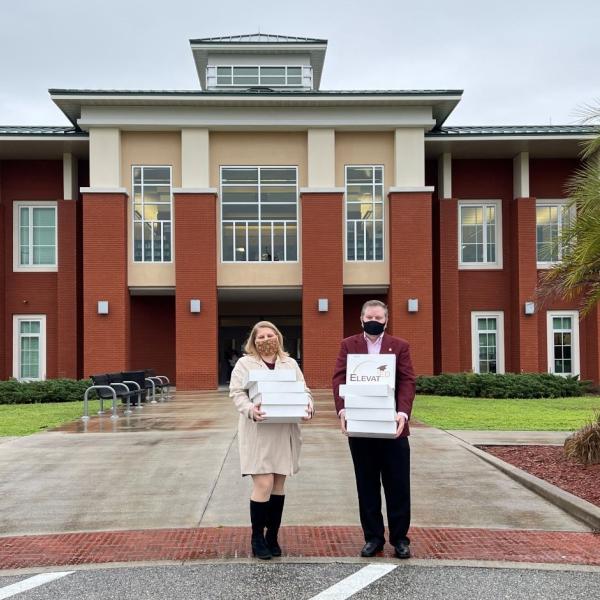 Two people delivering packages to school