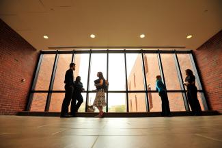 Students talking in the hallway infront of a window