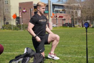 student kneeling on soccer field
