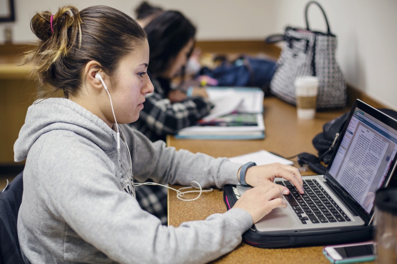 student typing on a computer